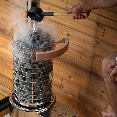 Water ladled onto a Titan SL1 heater with the alder heater guard at the top of the stone basket