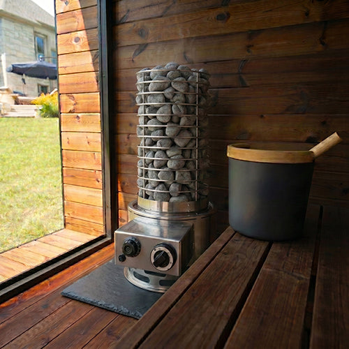 SaunaLife Titan SL1 installed in a wooden sauna on a stone floor tile beside a sauna bucket