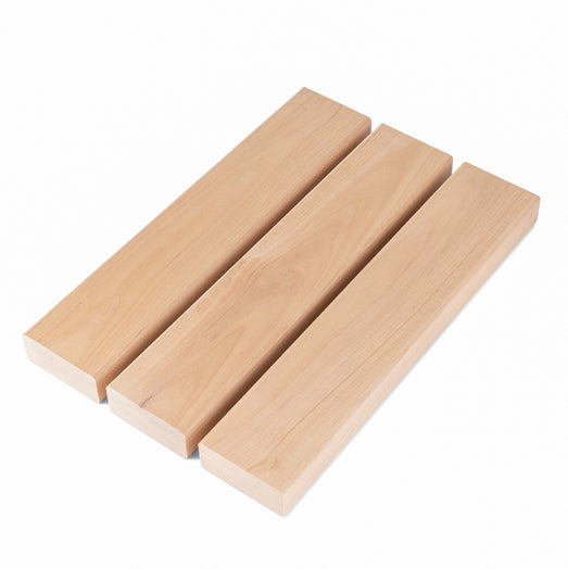 Three Alder 2x3 bench boards side by side at an angle, showing pale face grain and square ends