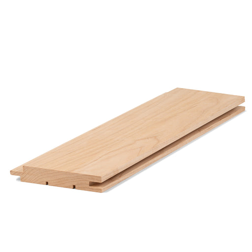 Alder 1x4 tongue-and-groove paneling board lying flat, angled view showing face grain and the grooved bottom edge