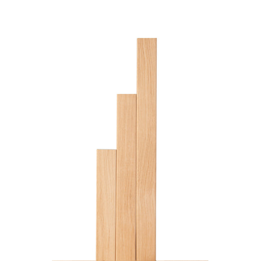 Three Alder 2x2 Trim pieces in stepped lengths standing side by side, showing pale, smooth face grain