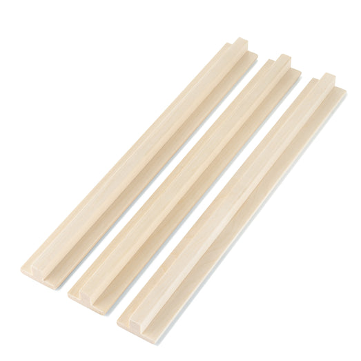 Three Aspen 1x2 T-Molding pieces side by side, parallel, with the raised rib facing up on each
