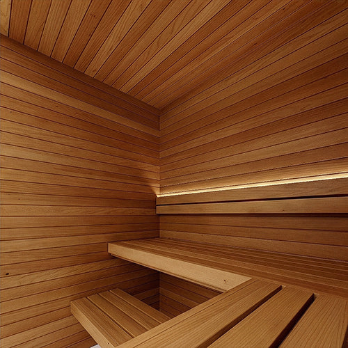Sauna interior corner with horizontal wall and ceiling paneling, an L-shaped bench and a soft light strip