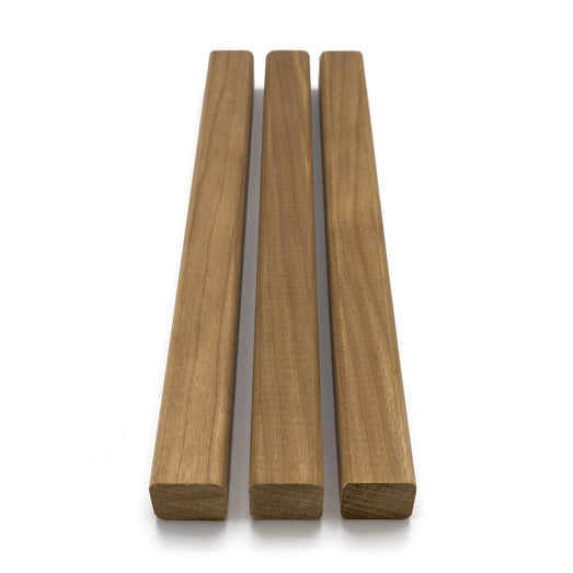 Three Thermo-Aspen 2x2 Trim pieces parallel on white, with square ends at the bottom and warm brown face grain