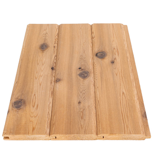 Three Western Red Cedar tongue-and-groove boards fitted together, close top view with knots and groove ends at the bottom