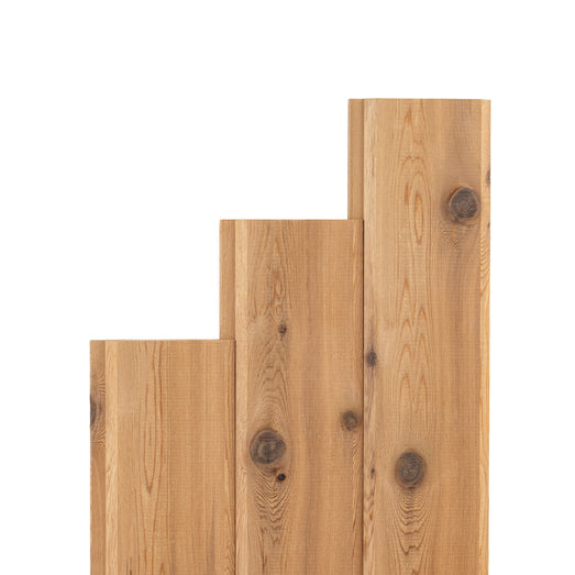 Western Red Cedar paneling boards in three stepped lengths, standing side by side with knotty face grain