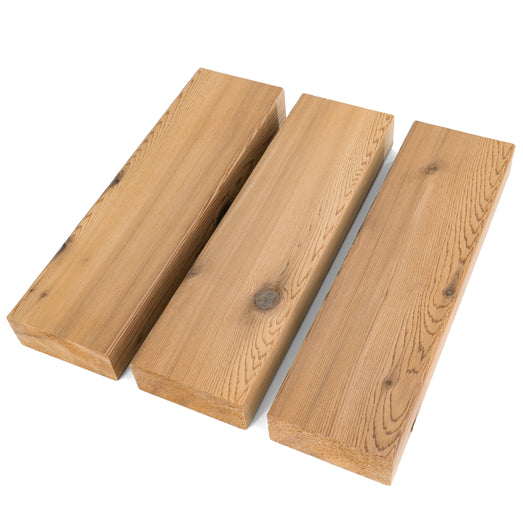 Three Western Red Cedar 2x4 bench boards laid side by side at an angle, showing knots and face grain