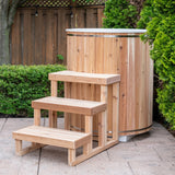 Baltic cold plunge tub with cedar steps on backyard patio beside hedge