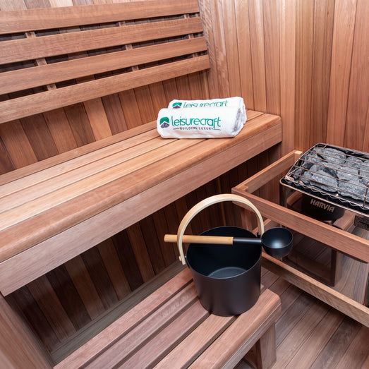 Dundalk Nook sauna interior with bench, water bucket and electric heater