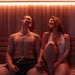 Woman relaxing on the bench inside the Dundalk Studio glass-front sauna