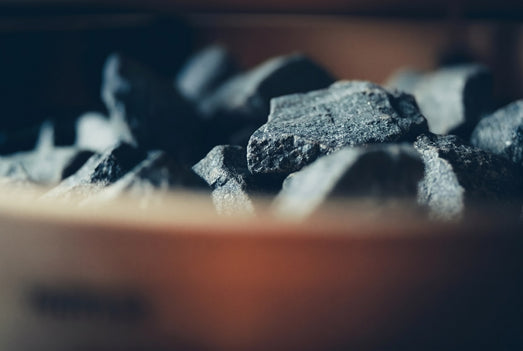 Close-up of dark sauna stones heating on a Harvia Legend wood-burning stove