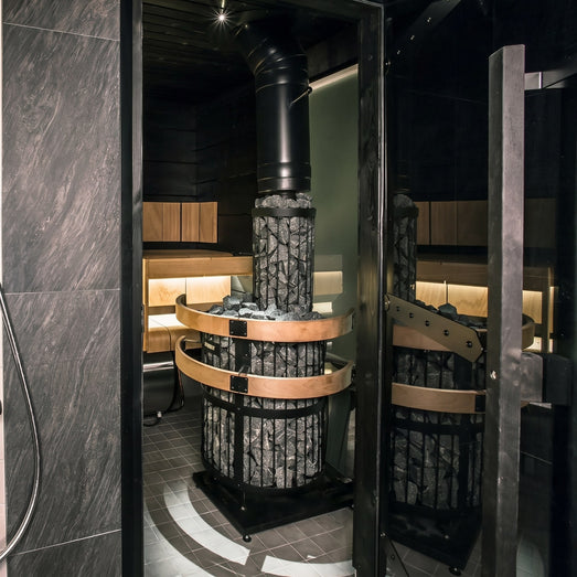 Harvia Legend Duo stone-column heater installed in a dark tiled sauna room