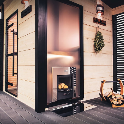 Harvia Legend Duo stove fed from outside a light-wood cabin sauna exterior