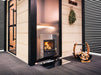 Harvia PRO DUO wood sauna stove installed in a sauna with log holder nearby