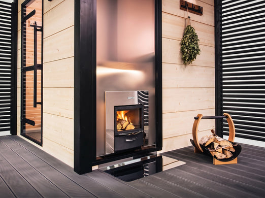 Harvia PRO DUO wood sauna stove installed in a sauna with log holder nearby