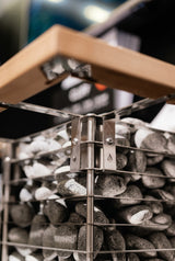Close-up of the HUUM Cliff heater mounting bracket beneath a sauna bench