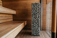 HUUM Cliff 6kW heater installed beside wooden benches in a modern sauna