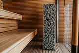 HUUM Cliff 6kW heater installed beside wooden benches in a modern sauna