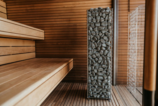 HUUM Cliff 6kW heater installed beside wooden benches in a modern sauna