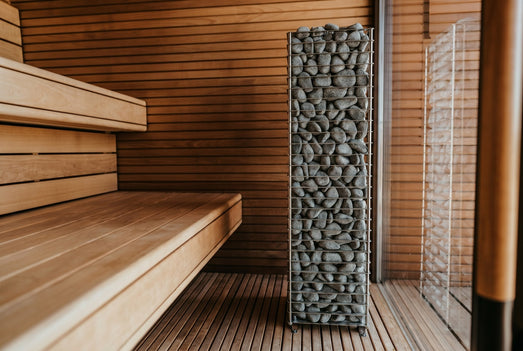 HUUM Cliff 6kW heater installed beside wooden benches in a modern sauna