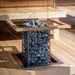 HUUM Cliff heater recessed into a light sauna bench with blue-gray stones