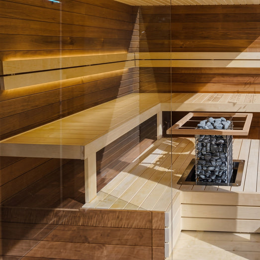 Wide view of a bright sauna interior with the HUUM Cliff heater in the corner
