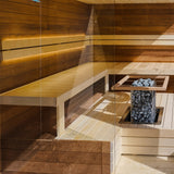 HUUM CLIFF 9kW heater with pale stones spotlit in a shadowed sauna corner