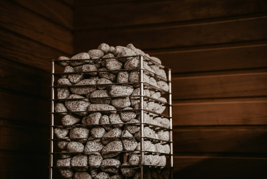 HUUM CLIFF 9kW heater stone basket close-up in a dimly lit cedar sauna