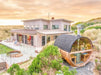 Outdoor barrel sauna with HUUM chimney beside a modern beach house