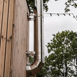 Close-up of HUUM backside chimney stainless pipe, elbow and wall brackets