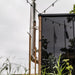 HUUM backside connection chimney running up the side of a glass-front outdoor sauna