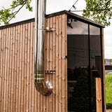HUUM backside connection stainless chimney installed on a wood outdoor sauna corner