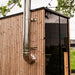 HUUM backside connection stainless chimney installed on a wood outdoor sauna corner