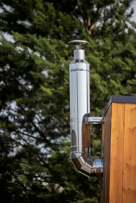 HUUM thru-wall stainless chimney installed on a cedar outdoor sauna exterior
