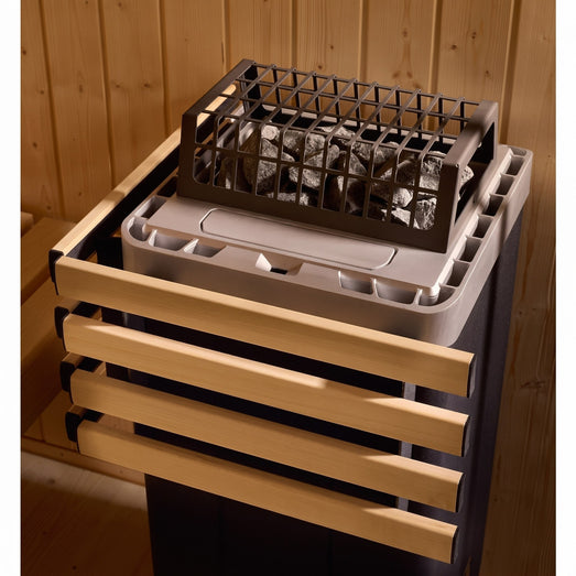 Close-up of the Kohler sauna heater stone bed behind its wood safety rail