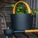 KOLO black sauna bucket and ladle on a rustic bench with birch leaves