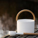 KOLO white sauna bucket and ladle resting on weathered lakeside dock boards