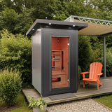 Logan 200D6 two person outdoor infrared sauna on a deck beside an orange chair