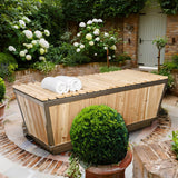 Covered Polar Cold Plunge Tub with towels in a courtyard garden with white hydrangeas