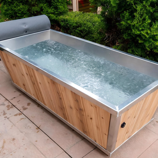 Polar Cold Plunge Tub filled with water on a patio beside green hedges outdoors