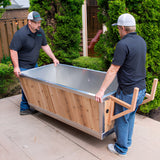 Two installers carrying the empty Polar Cold Plunge Tub across an outdoor patio