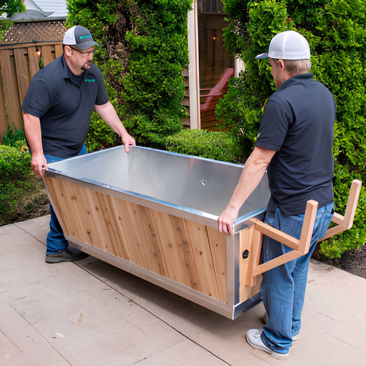 Two installers carrying the empty Polar Cold Plunge Tub across an outdoor patio