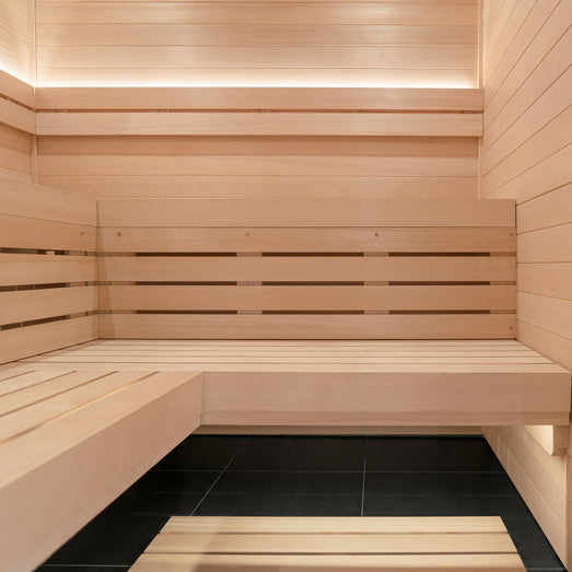ProSaunas LED strips along the upper wall cove and the bench of a light-wood sauna