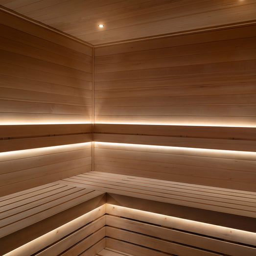 ProSaunas LED strips under the backrest and bench tiers of a light-wood sauna