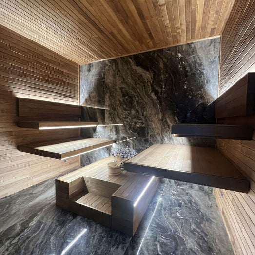 ProSaunas LED strips under floating benches in a sauna with a stone feature wall