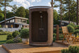 SaunaLife R3 outdoor barrel shower on a landscaped patio with garden chairs