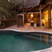 SaunaLife R3 outdoor barrel shower beside a pool at a wooded lodge at dusk