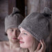 Woman and man wearing Rento linen terry sauna hats in a wooden sauna