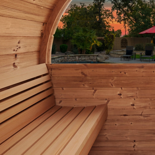 SaunaLife E6 sauna bench and window framing a backyard pool at sunset