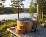 SaunaLife S4 hot tub steaming on a lakeside deck at golden hour with forest backdrop